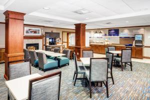 a restaurant with tables and chairs and a fireplace at Holiday Inn Express Hotel & Suites Hampton South-Seabrook by IHG in Seabrook