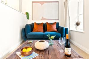 a blue couch in a living room with a wooden table at Stylish cosy retreat with private parking in Penryn