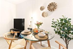 a dining room with a glass table and chairs at Stylish cosy retreat with private parking in Penryn
