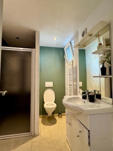 a bathroom with a white sink and a toilet at Yamohome in Brussels