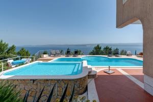 a swimming pool with a view of the ocean at Apartments Majda in Lokva Rogoznica