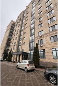 イルピンにあるCozy 2-room apartment in the center of Irpinの大きな建物の前に駐車した車両2台