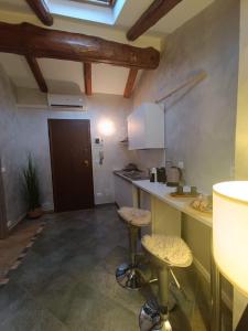 una cucina con un bancone e sgabelli in una stanza di La Mansardina di Sabrina a Busca