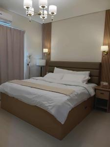 a bedroom with a large bed and a chandelier at Casa Thea Cebu in Talisay