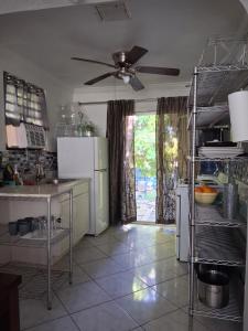 Una cocina con electrodomésticos blancos y un ventilador de techo. en El Mamey, en Miami