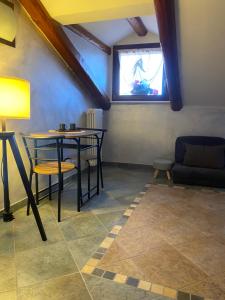 a room with a table and chairs and a window at La Mansardina di Sabrina in Busca
