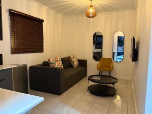 ソウェトにあるFUSH guesthouseのソファと鏡が2つあるリビングルーム