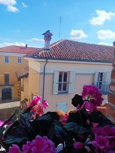 a view of a house with pink flowers in the foreground at La Mansardina di Sabrina in Busca