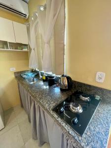 a kitchen counter with a stove top in a room at Mini Casa 5 in Itajaí