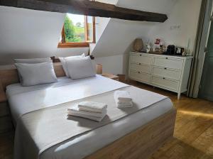 a bedroom with a large bed with towels on it at Le Cocon - Domaine du Vertendre in Saint-Yrieix-la-Perche
