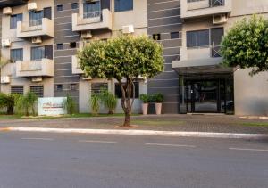 a tree sitting in front of a building at FLORENÇA PALACE HOTEL in Lucas do Rio Verde