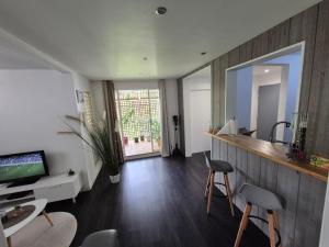 a living room with a tv and a mirror at Sensalys in Sainte-Rose