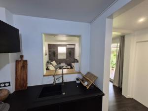 a kitchen with a sink and a large mirror at Sensalys in Sainte-Rose +1 photo