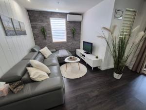 a living room with a couch and a television at Sensalys in Sainte-Rose