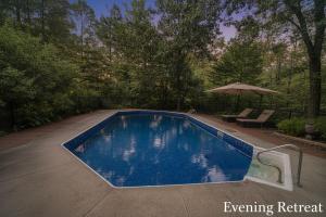 a swimming pool in a yard with an umbrella at Blue Bird Chalet 5BR with Sauna near Skiing in East Chatham