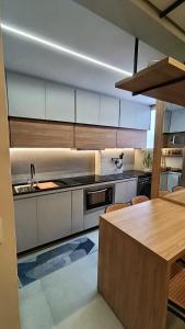 a kitchen with white cabinets and a table with chairs at Apartment Praia Clube Uberlandia in Uberlândia +34 photos