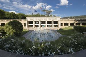 グレウー・レ・バンにあるStudio lumineux proche des thermes et du centre-village residence Parc Paradisの建物の前に噴水がある建物