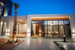 a house with a palm tree in front of it at شاليه مسا الفندقي in Buraydah