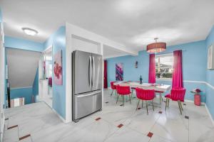 Il comprend une cuisine équipée d'un réfrigérateur et d'une table avec des chaises rouges. dans l'établissement Little Paris- In Affluent University HTS, à University Heights