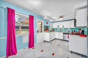 une cuisine avec des rideaux roses et une grande fenêtre dans l'établissement Little Paris- In Affluent University HTS, à University Heights