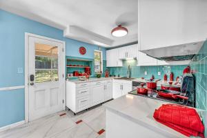 une grande cuisine avec des armoires blanches et des murs bleus dans l'établissement Little Paris- In Affluent University HTS, à University Heights