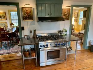 a kitchen with a stainless steel stove and a dining room at Historic Canal Home on Nature Preserve in Heathcote