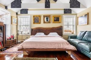 een slaapkamer met een groot bed en een bank bij Unique Luxury Central Historic Landmark Home in Lambertville