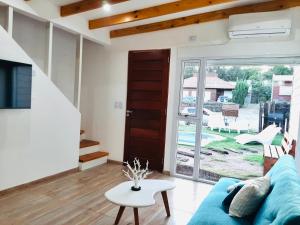 ein Wohnzimmer mit einem blauen Sofa und einem Tisch in der Unterkunft Casa Blanca MH in Monte Hermoso