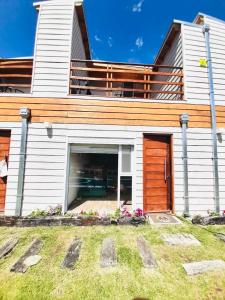 ein Haus mit Balkon und Garten in der Unterkunft Casa Blanca MH in Monte Hermoso