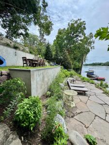a group of chairs and tables on a patio near the water at Charming & Whimsical Historic River Home in Titusville