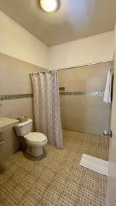 a bathroom with a toilet and a shower at Hospedaje Los Pavo Reales in Tepoztlán