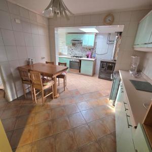 a kitchen with a table and chairs in a kitchen at Acogedora Casa con Tinaja y Jacuzzi y RENT A CAR in Puerto Varas