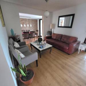 a living room with a couch and a table at Acogedora Casa con Tinaja y Jacuzzi y RENT A CAR in Puerto Varas