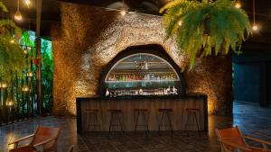 a bar in a building with a stone wall at Tocu Tent Camp in Caño Negro