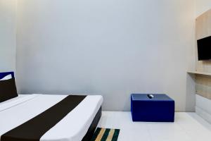 DevanandapurにあるHotel O Green Eco Spaceのベッドと青い箱のある寝室