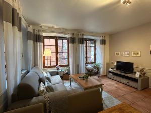 リクヴィールにあるle Roy de coeurのソファとテレビのあるリビングルーム