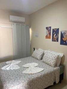 a bedroom with a bed with two white towels on it at Apartamento em Sinop 10 in Sinop