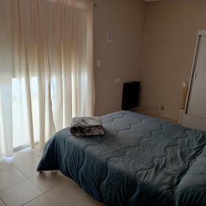 a bedroom with a bed and a large window at Apart Los Laureles Dpto 2 in Villa Regina