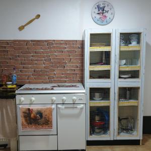 SotrondioにあるCasita de Aldeaのコンロのあるキッチンと時計のある壁