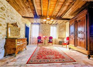 a room with chairs and a dresser and a rug at Château Arche d'Aure in Vicq-dʼAuribat