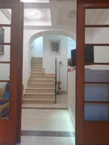 a hallway with stairs in a building with a door at Albergo Flaminia Rooms Grottarossa in Rome