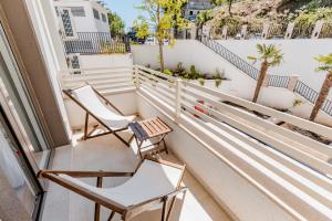 einen Balkon mit 2 Stühlen und Palmen in der Unterkunft Mira Bay in Igalo