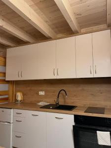 a kitchen with white cabinets and a sink at Rodzinna Przystań in Łupawa +8 photos