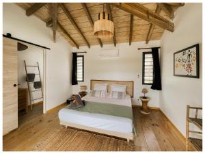 a bedroom with a bed and a wooden ceiling at Les pilotis in Courcelles Sucrerie