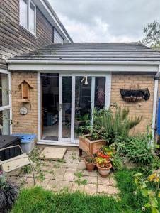 une terrasse couverte à l'avant d'une maison avec des plantes en pot dans l'établissement Stylish home, 3 bed with garden, Fast WiFi Parking, à Peterborough