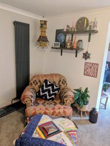 un salon avec un canapé et une chaise dans l'établissement Stylish home, 3 bed with garden, Fast WiFi Parking, à Peterborough