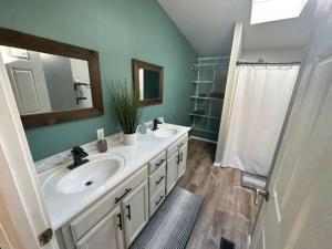 a bathroom with a sink and a mirror and a shower at Enchanting Getaway Farmhouse And Tiny House Duo in Jacksonville +35 photos