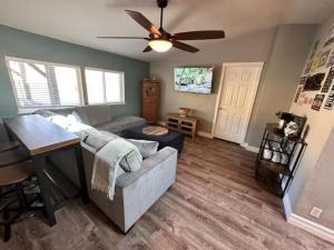 a living room with a couch and a ceiling fan at Enchanting Getaway Farmhouse And Tiny House Duo in Jacksonville