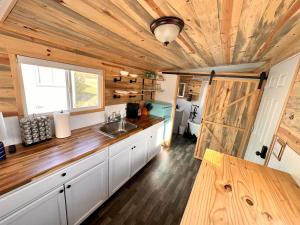 a kitchen with a sink and a wooden ceiling at Enchanting Getaway Farmhouse And Tiny House Duo in Jacksonville