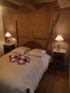 a bedroom with a large bed with two lamps on tables at Gite de traditions et charme Chez Montze in Hoerdt